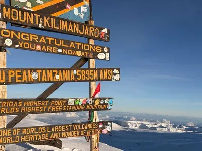 Uhuru Peak summit sign on Mount Kilimanjaro at 5,895 meters above sea level, Africa's highest mountain in Tanzania.